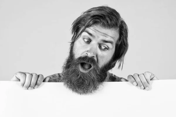 Étonné barbu brutal homme avec moustache tenir du papier merde pour l'espace de copie, annonce — Photo