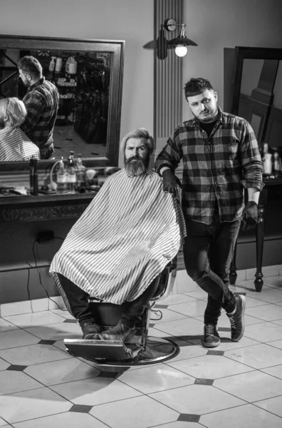 Şık ve kendinden emin. Erkek müşterisi olan profesyonel berber. Bıyıklı ve sakallı hippi. Adam yeni saç stili istiyor. Güzellik ve moda. Berber dükkanındaki adam. Kuafördeki vahşi sakallı adam. — Stok fotoğraf