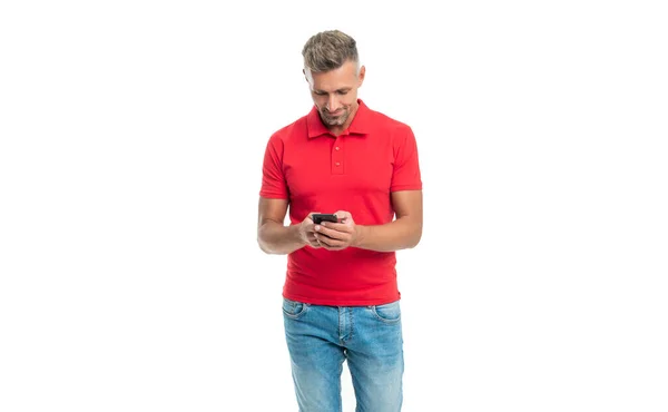Glücklicher Mann in rotem T-Shirt Nachrichten auf Smartphone isoliert auf weißem Hintergrund — Stockfoto