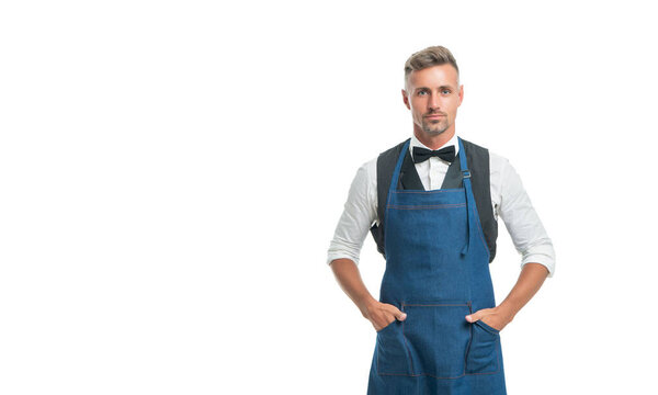 Serious chief cook keeping hands in chef apron pockets isolated on white, copy space