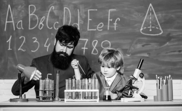 Lerarenman met kleine jongen. Biologie Wetenschapslab. Terug naar school. Vader en zoon op school. leerchemie in het schoollaboratorium. Wetenschappelijk onderzoek en experimenten. Verdwenen splijting — Stockfoto