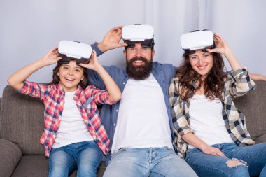 Mutlu ebeveynler ve küçük kız modern teknolojiyi evde kullanıyorlar. Anne, baba ve kızı..