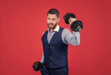 Güçlü iş adamı dambıl çalışır kırmızı arka plan, iş gücü