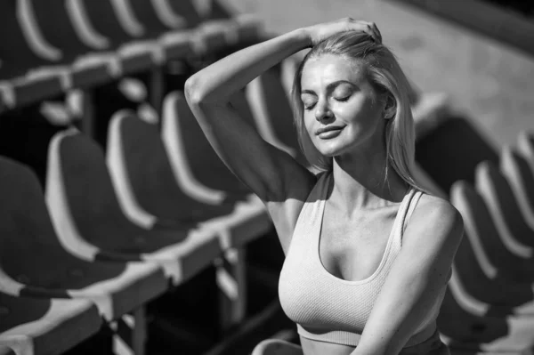 Ajuste senhora no desgaste fitness no estádio após o treino desportivo, relaxamento — Fotografia de Stock