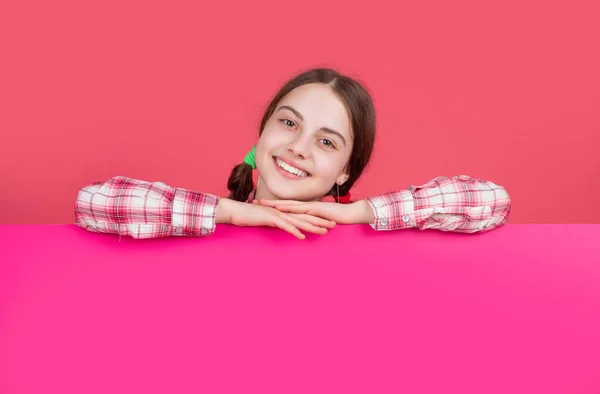 Щаслива дитина за порожнім рожевим папером з місцем для копіювання для реклами — стокове фото