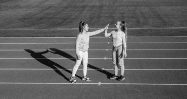 Küçük bir mola veriyoruz. Eğleniyorum. Genç kızlar stadyumda ısınıyor. Spor giyim bölümündeki çocuklar beş dakika ara veriyor. Çocuklar yarış pistinde egzersiz yaptıktan sonra rahatlarlar. sağlıklı çocukluk. Açık havada egzersiz yapmak.