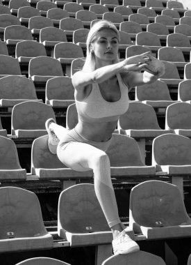 Stadyum koltuklarında esnek kadın spor giyim, esneklik.