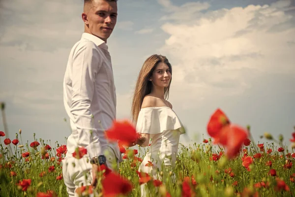 couple in love of man and woman in summer poppy flower field, love