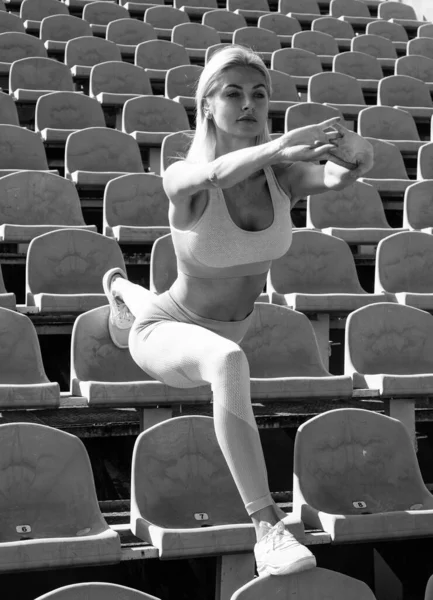 Stadyum koltuklarında esnek kadın spor giyim, esneklik.