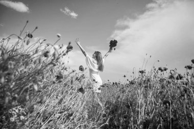 Mutlu ol. Yaz tatili ve tatil. Gelincik tarlasında yürüyen beyaz elbiseli güzel bir kadın. Meadow 'da gelin. Romantik ruh hali. Bahar doğasının güzelliği. Bir buket kırmızı çiçekli mutlu kız