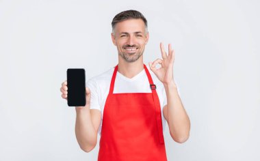 Önlüklü mutlu olgun bir adam akıllı telefona fotokopi alanı sunuyor. Tamam