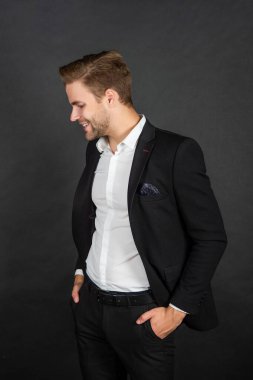 Siyah arka planda takım elbiseli mutlu genç adam, moda.