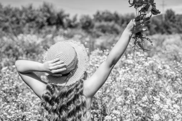 健康なカールのための植物のヘアケア製品。女の子は波打つ髪に帽子をかぶる。ヘアサロン。スパと美しさ。夏のヘアケア。花の香りシャンプー。ハーブケア。天然化粧品。自然は最もよく知っている — ストック写真