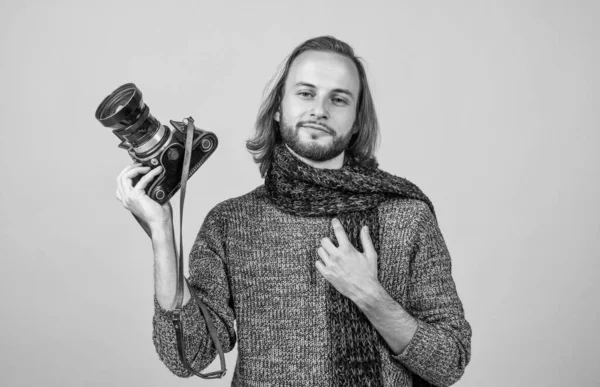 긴 머리에 사진 카메라를 들고 있는 사진사는 뜨개질 스웨터와 목도리를 착용하고 사진을 찍는다 — 스톡 사진