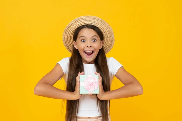 Surprised teen kid hold present box on yellow background — Stock Fotó
