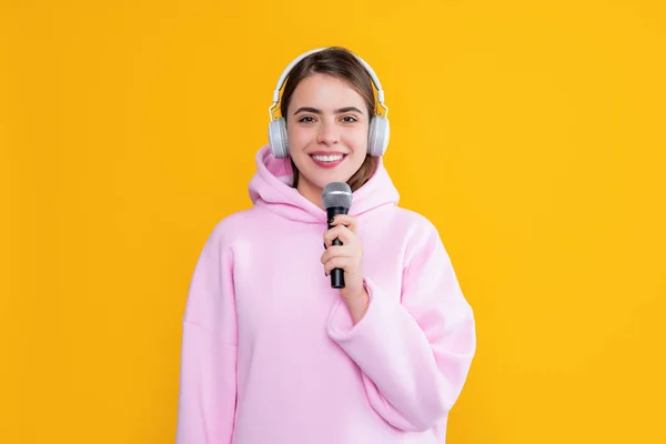Χαρούμενο νεαρό κορίτσι με ακουστικά με μικρόφωνο σε κίτρινο φόντο — Φωτογραφία Αρχείου