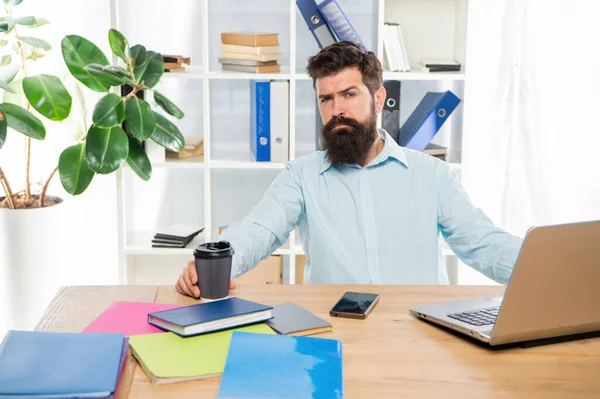 Tipo cansado bebiendo café para llevar trabajando en el escritorio de la oficina, pausa para el café — Foto de Stock