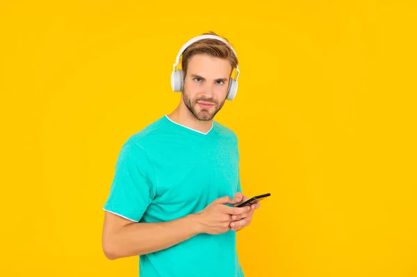 Du är vad du lyssnar på. Killen lyssnar på mobilmusik. Lyssna på spellista med hörlurar — Stockfoto