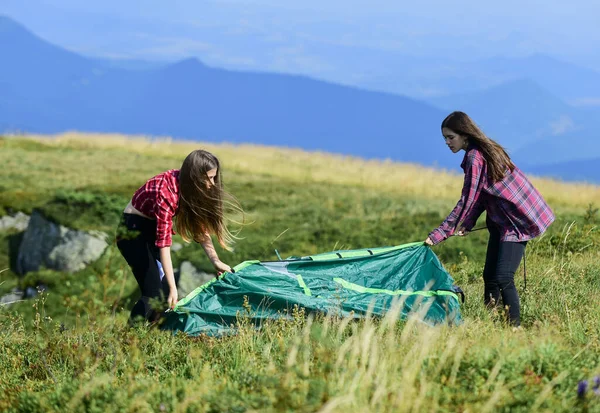 Lets go camping. family camping. reach destination place. friends spend free time together. two girls pitch tent. wanderlust discovery. hiking outdoor adventure. mountain tourism camp — Stock Fotó