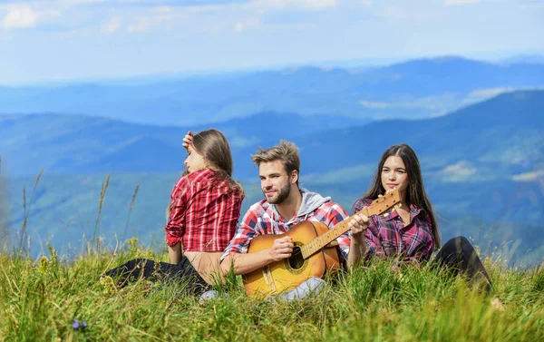 Outdoor adventure. hiking adventure. happy men and girls friends with guitar. friendship. romantic picnic in tourism camp. campfire songs. group of people spend free time together. family camping — стоковое фото