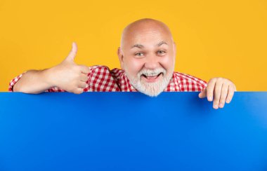 happy senior man with copy space on blank banner. advertising. thumb up