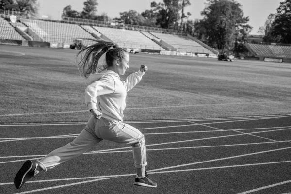 Koşmanın kuralı sadece koşmaktır. Enerjik kız koşu parkurunda koşuyor. Spor okulu — Stok fotoğraf