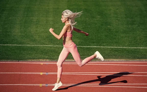 身强体壮的女运动员穿着运动服在体育场跑步，马拉松 — 图库照片