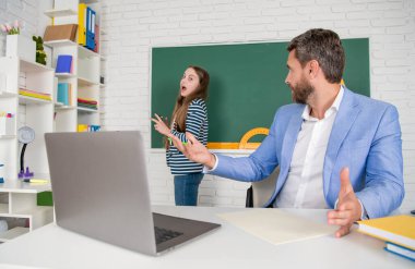 Sınıfta öfkeli bir öğretmen var. Tahtadaki çocuğa özen gösteriyor.