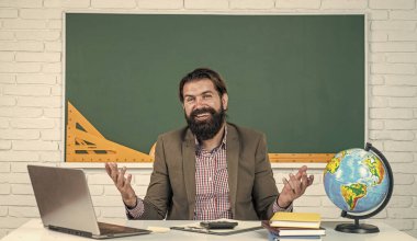 Güzel gülümseme. gayri resmi eğitim. Erkek öğrenci ders sırasında sınıfta oturur. Sınavı geç. Konuyu öğrenmek. Okula dönüyorum. Öğretmenler günün kutlu olsun. Sakallı vahşi adam kostüm giyiyor.