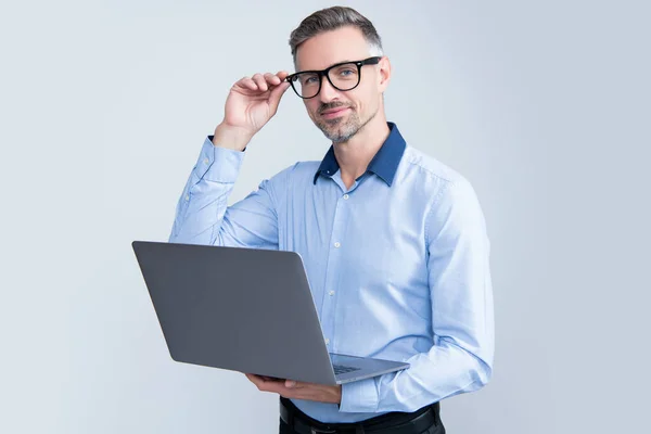 Mature entrepreneur in eyeglasses working on computer on grey background — Foto Stock
