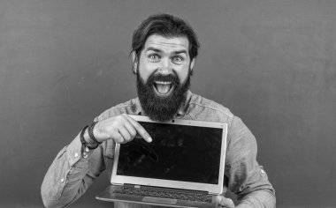 Sakallı ve bıyıklı bir adam üniversitede ya da okulda iş adamı ya da öğretmen gibi görünüyor.