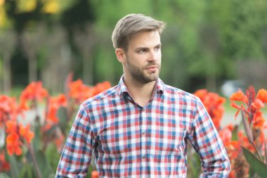 Dışarıdaki kareli gömlekli traşsız genç adam.