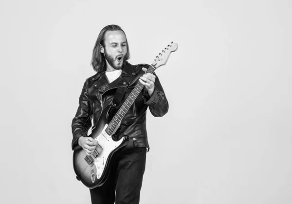 Емоційний бородатий рок-музикант грає на електрогітарі в шкіряній куртці, музиці — стокове фото