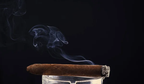 Sigaro cubano fumante con soffio di fumo sfondo scuro, spazio copia, fumo — Foto Stock