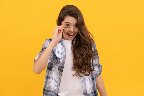 Amazed teen kid in checkered shirt and glasses on yellow background — Foto de Stock