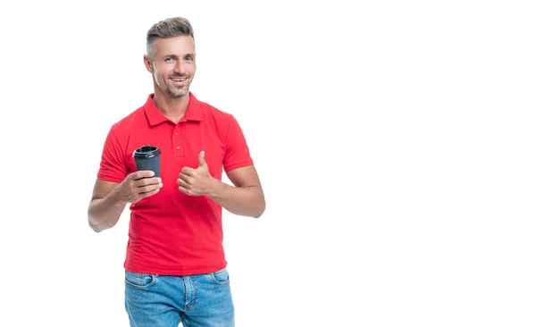Barista feliz en camiseta roja casual dando pulgar sosteniendo taza desechable con café para llevar — Foto de Stock