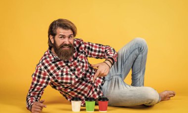 Adam kağıt bardaktan sıcak çay içiyor. Günaydın. Enerjik, sıcak içecek. İlham almak için kahve lazım. Mutlu sakallı adam sabah kahvesini içiyor.