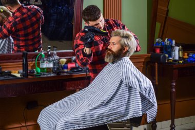 Moda onun hayatı. Kuaförde hippi tıraşlı bir adam. Sakal ve bıyık. Berber dükkanında profesyonel kuaför. Şık erkek sakalı portresi. Tıraş. Berber dükkanında kuaför.