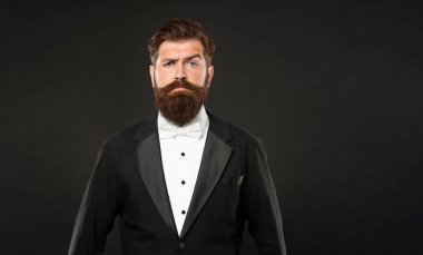 serious man in tuxedo bow tie. man in formalwear on black background. copy space.
