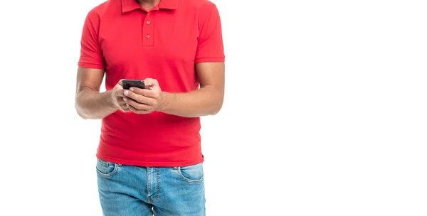 Hombre alegre en la mensajería de la camiseta roja en el teléfono inteligente aislado sobre fondo blanco — Foto de Stock