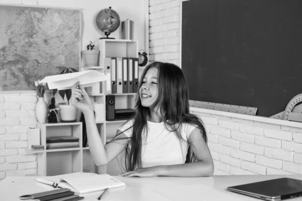 Laisse voler. développement de l'enfance. acquérir des connaissances par l'étude. gamin en classe avec tableau. enfant tenir avion en papier. retour à l'école. l'éducation formelle dans la vie moderne. concept d'enseignement à domicile — Photo