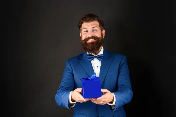 Happy man in tuxedo bow tie formalwear on black background presenting box. shopping sale — ストック写真