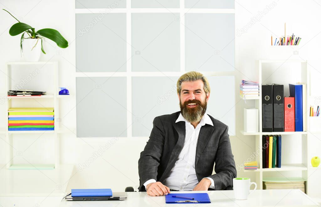 Quarantine during viral infection. Portrait of bearded man sitting at desk in office. confident brutal businessman. Elegant businessman analyzing data in office. Professional Office Corporate