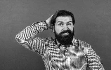 Kafası karışmış bir adam saçına dokunuyor.