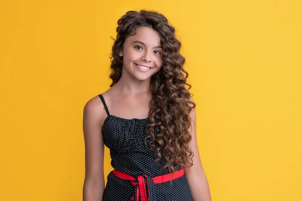 Happy child with long brunette afro hair on yellow background — Foto Stock