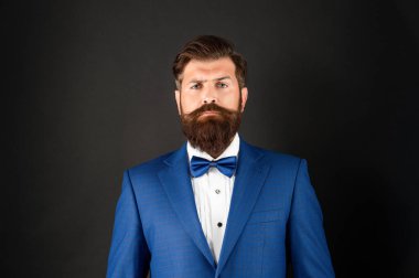 Smokin papyonlu ciddi bir adamın portresi. Siyah arka planda resmi giyinmiş gelin damat.