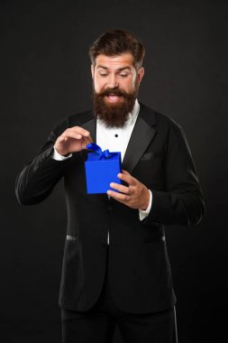 Smokinli, papyon takan, siyah arka planda, kutulu, hayret verici bir adam. Sevgililer Günü