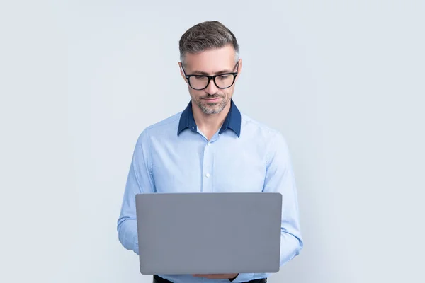 Impiegato maturo in occhiali da vista che lavora su computer su sfondo grigio — Foto Stock