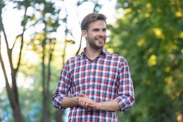 happy young man in checkered shirt outdoor