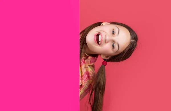 Ευτυχισμένη κοπέλα πίσω από λευκό ροζ χαρτί με αντίγραφο χώρο για διαφήμιση — Φωτογραφία Αρχείου